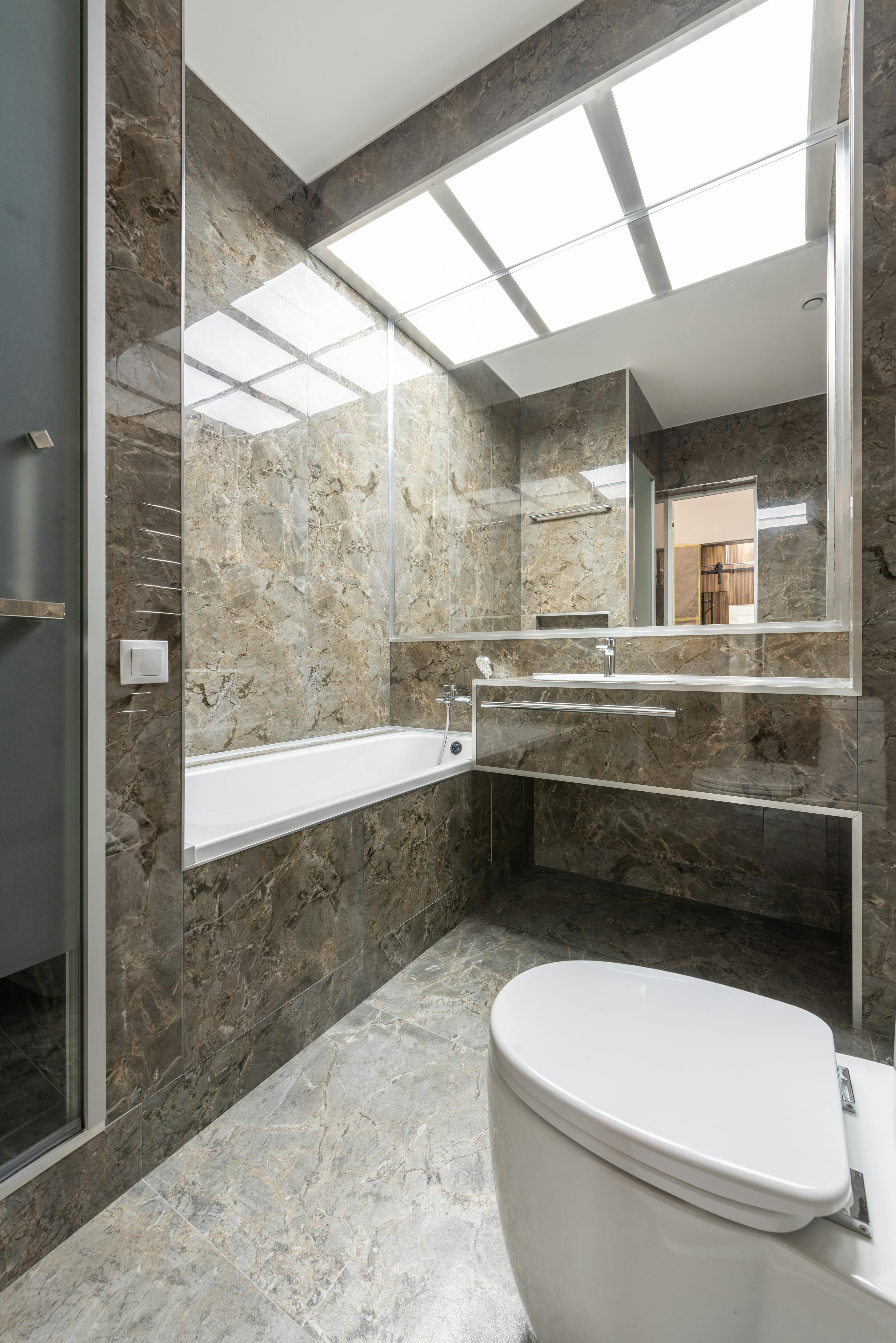 Bathroom with polished wall tiles, vanity, and glass shower finish