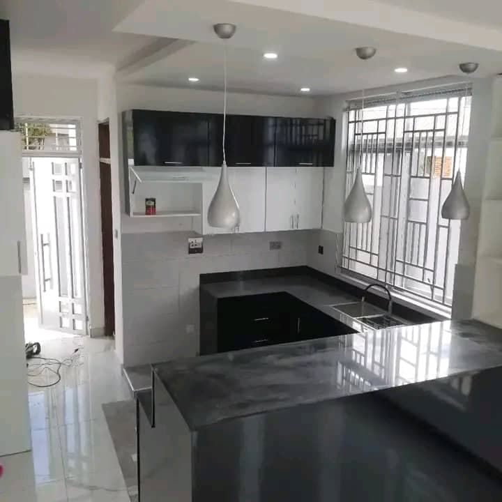 Compact kitchen finish with dark countertop and wall tiling