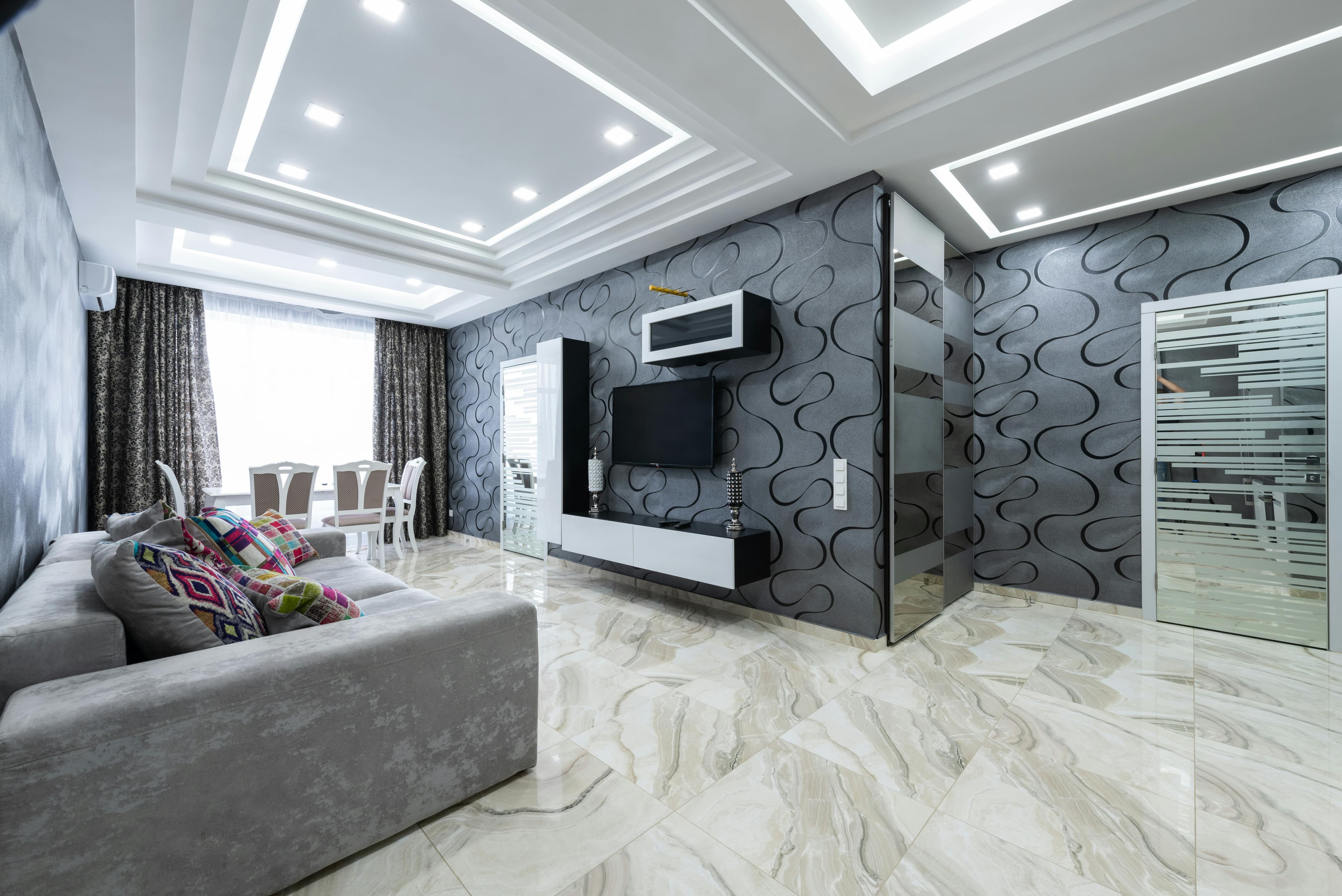 Modern sitting room with marble-look flooring and feature wall finishing