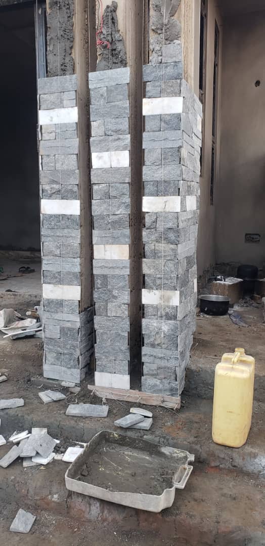 Stone cladding installation detail on a vertical feature surface
